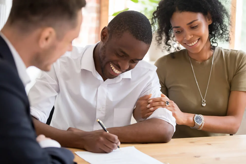 Happy african black family couple customers renters tenants sign mortgage loan investment agreement