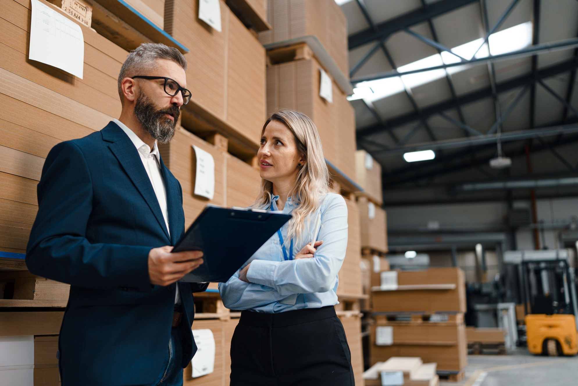 manager-reviewing-inventory-with-employee-warehouse