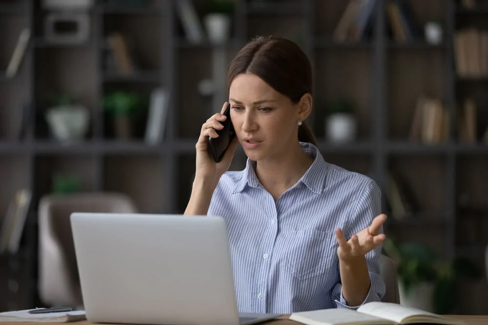 Bad things happen. Worried young lady manager calling client by cell to discuss breach of contract. Concerned millennial businesswoman sit at work desk talk to supplier about failure to meet deadlines