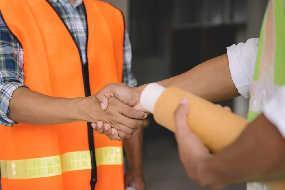 construction worker holding his colleague's hand