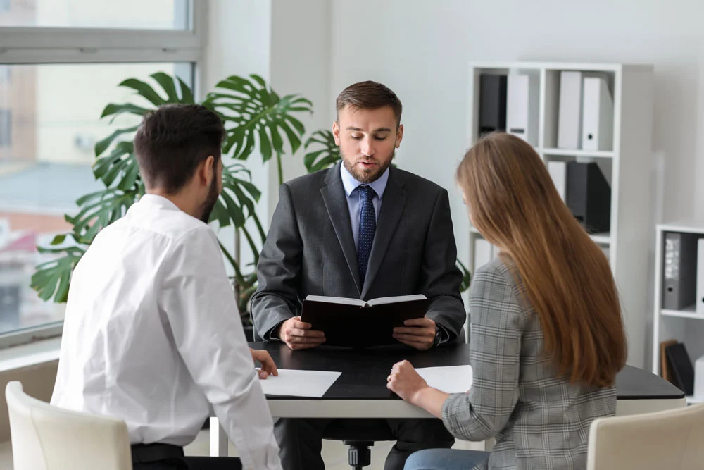 Unhappy young couple visiting divorce lawyer in office