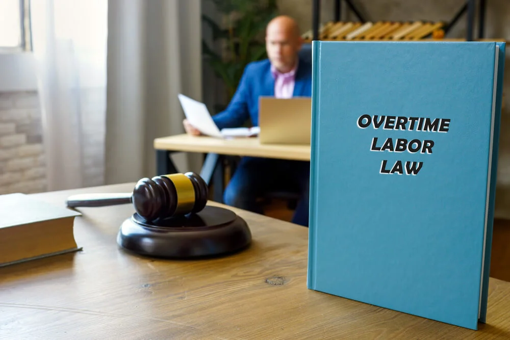 Attorney holds OVERTIME LABOR LAW book. Federal overtime laws are set forth in the Fair Labor Standards Act (FLSA)